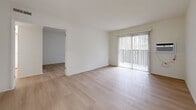 Located at 1560 S Highland Ave in Fullerton, CA, this 1-bedroom, 2-bathroom single-floor residence offers a thoughtfully laid-out living space with a clean, bright aesthetic throughout. Light wood-style flooring runs continuously across all rooms, creating a cohesive and airy feel.

The living room is generously proportioned and filled with natural light through a large sliding glass door fitted with vertical blinds, which opens directly onto a private balcony — ideal for enjoying the Southern California climate. A wall-unit air conditioner provides dedicated climate control. The open connection between the living room and dining room supports a flexible, comfortable flow for daily living.

The galley-style kitchen features white cabinetry, recessed lighting, a stainless steel sink, white appliances including an electric range, and ample counter space. A pantry provides additional storage adjacent to the kitchen area.

The primary bedroom is a comfortable, well-lit room with a window dressed in sheer vertical blinds that allow soft, diffused natural light. Two closets offer generous storage throughout the unit.

Both bathrooms are finished in a clean white palette; one includes a full tub/shower combination with tiled surround and updated chrome fixtures. The overall ambiance of the space is bright, neutral, and move-in ready.