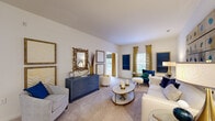 Located at 1450 Bluewater Way in Charleston, SC, this 2-bedroom, 3-bathroom single-floor residence offers a thoughtfully designed layout with a refined aesthetic. The spacious living area features vaulted ceilings and soft carpeting, bathed in natural light from large windows dressed with gold-toned drapes. The room flows seamlessly between two distinct seating areas, creating an inviting atmosphere for both relaxing and entertaining. The kitchen is equipped with black appliances, light wood cabinetry, granite countertops, and tile flooring, with an adjacent dining nook accented by bold artwork and elegant blue velvet seating. The primary bedroom is a generous, well-lit retreat with plush carpet, a ceiling fan, and a dedicated closet. The second bedroom features an en-suite bathroom and its own closet, offering added privacy. All three bathrooms are finished with granite-topped vanities, warm wood cabinetry, and tile flooring, with tub-shower combinations. Two dedicated closets provide ample storage throughout. The interior carries a consistent navy, gold, and white color theme, lending the space a polished, contemporary character that complements the Charleston setting.