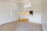 Located at 1211 S Quebec Way, this one-bedroom, one-bathroom residence is thoughtfully laid out across a single floor, making efficient use of its compact footprint. The living room is a standout space, featuring soaring vaulted ceilings that create an airy, open atmosphere, a classic corner fireplace with a clean white surround, and sliding glass door access to a private balcony. Natural light filters in through the vertical blinds, enhancing the bright, neutral palette throughout. Baseboard heating is present in both the living room and bedroom, ensuring year-round comfort. The galley-style kitchen is well-appointed with dark espresso cabinetry, light countertops, stainless steel appliances including a refrigerator, dishwasher, and range, and light hardwood-style flooring that extends into the hallway and bathroom. The bedroom is generously sized, featuring plush carpeting, a window with natural light, a textured ceiling, and direct access to a dedicated closet with louvered doors. The bathroom is clean and functional, with a full tub-shower combo, light wood-style flooring, and simple, classic finishes. A connecting hallway ties all rooms together for a cohesive and practical flow throughout the home.