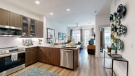 Located at 12500 Live Oak Way in Frisco, TX, this thoughtfully designed one-bedroom, one-bathroom residence offers an efficient and stylish single-floor layout. The open-concept living, dining, and kitchen area serves as the heart of the home, with light wood-style flooring flowing throughout and recessed lighting overhead. The kitchen is outfitted with rich dark-wood cabinetry, granite countertops, a subway tile backsplash, and a full suite of stainless steel appliances including a range, built-in microwave, dishwasher, and refrigerator. A peninsula with seating provides a casual dining option and connects seamlessly to the living area. The living room is bright and welcoming, featuring a ceiling fan and large windows with a glass door that opens to a private outdoor balcony, filling the space with natural light. The bedroom is a comfortable retreat with plush carpeting, generous windows, and access to a dedicated closet. The bathroom is clean and modern, finished with large-format tile and a soaking tub-shower combination with built-in niches. A dedicated laundry area completes this well-rounded residence, making it a functional and attractive home in the heart of Frisco.