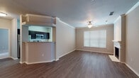 This single-floor residence offers a thoughtfully designed layout with a seamless flow between living spaces. The open-concept living and dining area is highlighted by rich hardwood-style flooring, crown molding, and a ceiling fan, creating a comfortable and polished atmosphere. Natural light filters in through large windows fitted with blinds, brightening the neutral-toned walls throughout.

The kitchen is a standout feature, equipped with dark espresso cabinetry, granite countertops, a classic white subway tile backsplash, and a full suite of stainless steel appliances including a refrigerator, electric range, microwave, and dishwasher. A pass-through bar connects the kitchen to the living area, enhancing the open feel. A door in the kitchen area provides convenient exterior access.

The bedrooms are carpeted for comfort, each offering generous proportions, ceiling fans or light fixtures, and large windows that invite natural light. The two full bathrooms are consistently finished with dark-framed vanity mirrors, espresso cabinetry, granite countertops, and tiled shower-tub combinations, complemented by hardwood-style flooring. A fireplace is also visible in the living area, adding warmth and character to the overall space.