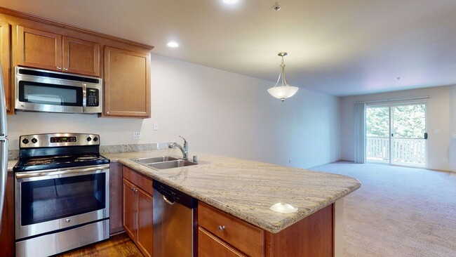 Stunning Kitchen and Living Room with Stainless steel appliances, lots of counter space and cabinet storage, and a dining area. - Windsong