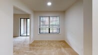 This single-floor Oxford residence in Edison, NJ offers a well-organized one-bedroom, one-bathroom layout designed for comfortable everyday living. The living area is generously proportioned, featuring neutral wall-to-wall carpeting, a textured ceiling, and abundant natural light from a large window paired with a sliding glass door that opens to an outdoor patio with exterior views. The open sightline between the living and dining areas creates a connected, airy feel throughout the main space.

The galley-style kitchen is efficiently arranged, featuring cream-toned cabinetry with wood-accented hardware, warm butcher-block style countertops, and white appliances including a gas range and full-size refrigerator. Vinyl flooring and overhead cabinets maximize storage and functionality within the compact layout.

The bedroom continues the neutral, light-filled aesthetic with carpeted flooring, a large window that draws in natural light, and ample wall space. A textured ceiling is consistent throughout the unit.

The bathroom includes a full tub and shower combination with a curtain rod, a toilet, and classic subway tile wainscoting, maintaining a clean, simple design. Overall, the unit presents a practical and comfortable living environment in a convenient Edison location.