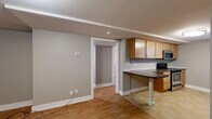 Located at 3701 Davenport St in Omaha, Nebraska, this single-floor, one-bedroom, one-bathroom unit offers a practical and well-organized layout. The space is finished in neutral gray tones throughout, creating a cohesive and calm aesthetic.

The kitchen is equipped with light maple cabinetry offering ample storage, dark laminate countertops, a stainless steel range with overhead microwave, and tile flooring. A window brings in natural light, and a built-in peninsula counter provides additional workspace. The open sightline from the kitchen into the living area enhances the sense of space.

The bedroom features warm hardwood-style flooring, soft gray walls, and two windows that allow natural light to fill the room. A ceiling fan with integrated lighting provides both comfort and illumination.

The full bathroom includes a soaking tub with tiled surround, a pedestal sink, a mirrored medicine cabinet with overhead lighting, and tile flooring — all finished in clean white and neutral tones.

A secondary room with hardwood-style flooring and white panel door provides additional flexible space. Overall, this unit offers a clean, move-in-ready environment with functional finishes suited for comfortable everyday living.