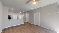 This two-story home in Farmington, Arkansas offers a clean, modern design with a neutral color palette and thoughtful finishes throughout. The main level features an open-concept living area with durable wood-look flooring, recessed lighting, and ceiling fans that provide both comfort and style. The living space flows seamlessly into the kitchen, which is outfitted with crisp white shaker-style cabinetry, granite-look countertops, a classic subway tile backsplash, and a full suite of stainless steel appliances including a refrigerator, range, microwave, and dishwasher. A raised breakfast bar adds additional functionality to the space. Natural light filters in through blinded windows, creating a bright and welcoming atmosphere on both floors. The bathrooms feature clean, all-white tub and shower combinations with chrome fixtures. The bedrooms are carpeted for warmth and comfort, each equipped with ceiling fans and generous natural light from well-placed windows. The staircase connecting the two levels is neatly integrated into the main living area. Throughout the home, five-panel interior doors and consistent trim work contribute to a cohesive, contemporary aesthetic that is both practical and visually appealing.