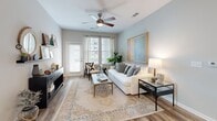 Located at 201 Sawyer Cir in Charleston, SC, this well-designed two-bedroom, one-bathroom home offers a thoughtful single-floor layout with approximately 1,000 square feet of living space. The kitchen is a standout feature, outfitted with slate-gray shaker cabinets, white quartz countertops, a subway tile backsplash, and a full suite of stainless steel appliances. A central island with seating provides an ideal space for casual dining, while pendant lighting adds a polished touch overhead. Wood-look flooring runs throughout the main living areas, lending warmth and continuity to the space. The living room is bright and welcoming, featuring large windows and a glass door that invite natural light and outdoor views. A ceiling fan adds comfort, and the neutral color palette creates a calm, versatile atmosphere. Both bedrooms are carpeted and equipped with ceiling fans, offering a cozy retreat. The primary bedroom is generously sized, with dual windows providing ample natural light. Two closets throughout the home offer practical storage solutions. The bathroom is clean and functional, featuring a tub-shower combination with built-in shelving and wood-look flooring. Overall, this home delivers a modern, comfortable living experience in the heart of Charleston.