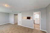 This two-story residence at 515 Gardere Ln in Baton Rouge, Louisiana offers a practical and well-appointed layout across two floors. The main level features a living room with soft carpeting and a pass-through opening to the kitchen, which is equipped with white cabinetry, marble-style countertops, wood-look flooring, and black appliances including a refrigerator and dishwasher. Built-in corner shelving adds additional storage convenience to the kitchen area. Three bathrooms are distributed throughout the home, each featuring white vanities with marble-style countertops and large mirrors. The upper level houses two carpeted bedrooms, both fitted with ceiling fans and windows that allow natural light to filter in. The generously sized primary bedroom includes a closet and its own bathroom access. The second bedroom is bright and comfortable, with an outdoor-facing window. A dedicated laundry room comes equipped with a full-size washer and dryer, along with wire shelving for storage. Neutral gray walls, white trim, and consistent finishes throughout the home create a clean and cohesive aesthetic. This residence combines functional design with modern touches in a convenient Baton Rouge location.