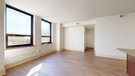 Located at 811 Grand Blvd in the heart of Kansas City, MO, this single-floor unit offers a well-designed layout with a clean, contemporary aesthetic throughout. The open living area is finished with warm hardwood-style flooring and bright white walls, creating an inviting and versatile space. Large, dark-framed windows flood the room with natural light and frame views of the surrounding urban landscape.

The kitchen is a functional centerpiece, featuring rich dark-wood cabinetry, stainless steel appliances including a range, microwave, and refrigerator, and a tile backsplash. A spacious island with a built-in sink provides additional prep and storage space, making it ideal for everyday use.

The bedrooms are comfortably sized and carpeted for warmth, each benefiting from natural light through large windows with blinds. At least one bedroom includes a closet with built-in rod storage and direct access to an adjoining room. The bathroom is well-appointed with a full tub-shower combination, tile surround, and dark-wood vanity with a granite-style countertop.

Throughout the unit, consistent trim work, recessed lighting, and neutral tones contribute to a cohesive and modern feel, well-suited for urban living in downtown Kansas City.