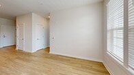 Located at 4824 Walmsley Blvd in Richmond, VA, this well-appointed two-bedroom, two-bathroom apartment offers a thoughtfully designed single-level layout. Light wood-style flooring runs throughout the unit, creating a cohesive and contemporary aesthetic.

The kitchen is a standout feature, showcasing rich dark-stained cabinetry, granite countertops, a stainless steel sink with a gooseneck faucet, and a full suite of stainless steel appliances including a range, over-the-range microwave, dishwasher, and refrigerator. Recessed lighting illuminates the space effectively.

The living area is bright and airy, featuring a ceiling fan, large windows with exterior views, and a private door providing outdoor access, filling the room with natural light.

The spacious primary bedroom includes its own en-suite bathroom with a granite-topped double vanity, dark cabinetry, and a large mirror, along with a walk-in closet equipped with wire shelving systems offering generous storage. The second bedroom is well-sized, also featuring a ceiling fan and a window with outdoor views.

The second bathroom includes a granite vanity, a tub-shower combination, and direct access to an additional closet. Both bedrooms offer comfortable proportions and a clean, neutral palette throughout.