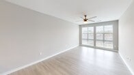 Located at 2120 N Brevard Street in Charlotte's NoDa neighborhood, this one-bedroom, one-bathroom unit offers a well-designed layout with contemporary finishes throughout. The open-concept living and kitchen area is anchored by light hardwood-style flooring and large windows that invite an abundance of natural light, complemented by a ceiling fan for year-round comfort. The kitchen is a standout feature, boasting rich dark cabinetry, granite countertops, stainless steel appliances including a refrigerator, range, and built-in microwave, and a peninsula with pendant lighting that serves as both a prep space and casual dining area. The bedroom is a comfortable retreat, finished with plush carpeting, neutral gray walls, and a window with slatted blinds that allows for controlled natural light. A dedicated closet provides convenient storage. The bathroom is clean and classic, featuring a full tub and shower combo tiled in crisp white subway tile with built-in shelving for added functionality. The unit's consistent use of neutral tones and modern materials creates a cohesive, move-in-ready aesthetic suited for urban living in Charlotte.