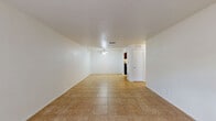 This 680 square foot apartment in Summit West offers a practical and efficient living space. The unit features a modern kitchen with rich wood cabinetry, granite countertops, and black appliances, including a full-size refrigerator. The galley-style kitchen layout maximizes functionality in the compact space.

The living area is spacious and bright, with large windows providing natural light and an exterior view. The room is versatile, accommodating both living and dining spaces. Smooth tile flooring throughout the main living areas adds a clean, contemporary feel.

The bedroom is generously sized at 160 square feet, featuring plush carpeting for comfort and a large window for natural light. A sliding door closet provides ample storage space. The bathroom, while not pictured in detail, appears to have a standard tub-shower combination with white tiling for a clean, classic look.

The apartment includes the convenience of in-unit laundry, visible through the kitchen area. The overall design emphasizes practicality and efficient use of space, making this one-bedroom unit an ideal option for singles or couples seeking a modern, low-maintenance living space in the Summit West complex.