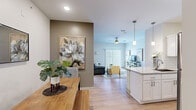 Located at 6386 Transit Rd in Depew, NY, this thoughtfully designed single-floor residence offers three bedrooms and three full bathrooms within a well-appointed layout. The open-concept living, dining, and kitchen area forms the heart of the home, finished with warm light wood flooring that flows throughout. The kitchen is equipped with crisp white shaker cabinetry, granite countertops, a subway tile backsplash, stainless steel appliances, and a peninsula that doubles as a breakfast bar with pendant lighting above. The dining area features an accent wall that adds warmth and character, while the living room benefits from a ceiling fan and large sliding glass doors that invite natural light and provide outdoor access. The spacious primary bedroom includes a walk-in closet with built-in wire shelving and an en-suite bathroom featuring a combination tub and shower and a vanity with granite countertops. The additional bedrooms are carpeted, bright, and generously sized, each with ceiling fans and windows overlooking the surroundings. The bathrooms maintain a clean, modern aesthetic consistent with the rest of the home. Two closets provide ample storage, and the overall design reflects a contemporary, move-in-ready sensibility throughout.