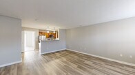Located at 17955 Murray Pl in Noblesville, Indiana, this well-appointed one-bedroom, one-bathroom home offers a thoughtfully designed single-floor layout with approximately 700 square feet of living space. The interior is finished with light-toned luxury vinyl plank flooring throughout the main living areas, complemented by neutral gray walls and clean white trim that create a bright, cohesive aesthetic.

The open-concept living room is generously proportioned, featuring multiple windows with blinds that invite natural light and a front entry door flanked by additional windows. The space flows seamlessly into the kitchen, which is defined by a raised breakfast bar peninsula. The kitchen is equipped with warm-toned wood cabinetry, light granite-style countertops, stainless steel appliances including a refrigerator, range, and microwave, and a double-basin sink.

The bedroom offers comfortable proportions with plush carpeting, a large sliding glass door bringing in outdoor light, and direct access to the kitchen area. The bathroom features matching wood cabinetry with a granite-topped vanity, LVP flooring, and grab bars, providing both style and functionality. A dedicated closet completes the floor plan, offering practical storage. The overall ambiance is clean, modern, and move-in ready.