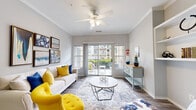 Located at 6200 Birkdale Valley Dr in Charlotte, NC, this single-floor residence offers a thoughtfully designed layout that balances comfort and functionality. The living room serves as the heart of the home, featuring wood-style flooring, crown molding, a ceiling fan, and large sliding glass doors that open onto a private balcony, flooding the space with natural light and providing outdoor views. Built-in shelving adds both character and practical storage to the living area.

The kitchen is well-appointed with light wood cabinetry, stainless steel appliances including a range, microwave, and dishwasher, and a peninsula counter that doubles as a breakfast bar. Wood-style flooring carries through this space, creating a clean and cohesive look that connects seamlessly to the adjacent dining area.

The bedrooms are carpeted for comfort and include generous closet space. Each room benefits from natural light through well-placed windows, and ceiling fans provide year-round climate comfort.

The bathroom features wood-style tile flooring, a full tub-shower combination, a wide vanity with ample counter space, and a large mirror. The neutral gray tones throughout create a calm, clean aesthetic.

Overall, this residence presents a bright, well-maintained living environment in the Ballantyne area of Charlotte, NC.