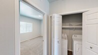 Located on Mt. Rushmore Road in Rapid City, South Dakota, this single-floor, three-bedroom, two-bathroom residence offers a practical and modern layout. The kitchen is a standout feature, equipped with dark shaker-style cabinetry, marble-look countertops, black appliances including a range, built-in microwave, and dishwasher, along with pendant lighting and durable hardwood-style flooring. The combined kitchen and living area flows naturally, with a sliding glass door in the living room opening onto a private balcony that overlooks the surrounding landscape under open South Dakota skies. The three bedrooms are finished with plush carpet and neutral-toned walls, providing a calm and comfortable atmosphere. The primary bedroom offers a generous footprint with ample natural light. Both bathrooms are finished with dark vanity cabinetry, marble-look countertops, and clean white fixtures, with one featuring a walk-in shower. A dedicated in-unit laundry closet with full-size washer and dryer hookups adds everyday convenience. Throughout the home, neutral gray walls and consistent finishes create a cohesive, move-in-ready aesthetic suited for comfortable living in the Rapid City area.