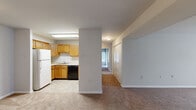 This single-floor residence offers a well-organized layout comprising three bedrooms, one bathroom, a living room, a kitchen, and two closets. The living room is generously proportioned, featuring neutral-toned carpet flooring and a large sliding glass door that fills the space with natural light. The kitchen is efficiently arranged in a U-shaped configuration, outfitted with warm honey-toned wood cabinetry, ample upper and lower storage, a white refrigerator, a white electric range, a black dishwasher, a single-basin sink, and light tile flooring. The primary bedroom is notably spacious, offering plenty of room for furnishings, and is finished with the same soft carpeting found throughout the home. The two additional bedrooms are well-sized, each featuring carpet flooring and windows that bring in natural light, making them suitable for a variety of uses. The bathroom is clean and straightforward, featuring a full tub-shower combination with white tile surround. Consistent neutral wall tones and carpet flooring throughout the living areas and bedrooms create a cohesive and move-in-ready aesthetic. Two closets provide practical storage solutions within the home.