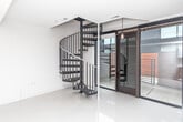 Located at 1242 Morse Ave in Royal Oak, Michigan, this contemporary two-floor space showcases a clean, modern design throughout. The open-plan main level centers around a well-appointed kitchen featuring stainless steel appliances, including a gas range, built-in microwave, and French door refrigerator. Sleek white upper cabinetry contrasts with warm wood-toned lower cabinets and a matching kitchen island with a light quartz countertop. Track lighting illuminates the space, complementing the large-format white tile flooring that extends into the open living area, creating a bright and cohesive aesthetic. The bathroom exudes minimalist elegance, with polished tile flooring, a vessel sink atop a floating white vanity, a glass-accented mirror, and a spacious walk-in shower with wood-finish tile surround. A pendant light adds a refined touch to the space. A striking metal staircase with bold vertical railing connects the two floors, serving as both a functional and architectural feature. The upper level, visible from below, benefits from soaring ceilings and an open loft-like atmosphere. Throughout the space, white walls and carefully considered lighting create a bright, versatile environment well-suited to a variety of uses.