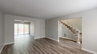 Located at 3232 Raleigh Dr in Toledo, OH, this two-story townhouse offers 3 bedrooms and 3 bathrooms thoughtfully distributed across two well-proportioned floors. The main level features a living room and dining room that flow seamlessly together, finished with contemporary wood-look laminate flooring and neutral gray walls that create a clean, modern aesthetic. A ceiling fan with light fixture accents the living area, which opens to the outdoors via a sliding glass door with vertical blinds, providing natural light and backyard access. The staircase, featuring wood-toned steps and white balusters, connects to the upper level. The kitchen and a full bathroom round out the main floor. Upstairs, three bedrooms offer comfortable private retreats, each featuring the same wood-look flooring, neutral tones, and natural light from well-placed windows. The primary bedroom is generously sized, while additional bedrooms provide flexibility for various uses. The bathrooms include white tile accents, pedestal-style sinks, and open shelving for storage. Five closets distributed throughout the home ensure abundant storage. The townhouse also benefits from a private outdoor space visible from the main level, framed by mature trees and fencing.