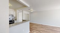 Located at 2000 Elmhurst Circle in Orion, Michigan, this well-appointed one-bedroom, one-bathroom residence offers a thoughtfully designed single-floor layout. The open-concept living, dining, and kitchen area serves as the heart of the home, featuring warm wood-style laminate flooring, neutral gray walls, and abundant natural light from well-placed windows. The kitchen is a functional highlight, outfitted with white cabinetry, granite countertops, a peninsula breakfast bar, stainless steel appliances including a gas range, dishwasher, and refrigerator, as well as a dedicated laundry area. The peninsula creates a natural division between the kitchen and the dining and living spaces, enhancing the open flow. Three closets throughout the unit provide generous storage. The spacious bedroom is carpeted for comfort and includes a dedicated closet and a window that brings in natural light. The bathroom features a full tub-shower combination with brushed nickel fixtures. A staircase provides access to additional areas of the building. The overall aesthetic is clean, modern, and move-in ready, with a neutral color palette that complements a variety of décor styles.