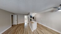 Located at 6263 Acorn Street in San Diego, CA, this single-floor, one-bedroom unit offers a thoughtfully arranged and efficient layout. The open-concept living and kitchen area is finished with warm wood-look vinyl flooring, neutral gray walls, and a textured ceiling, creating a clean and contemporary aesthetic throughout.

The kitchen is a standout feature, outfitted with bright white shaker-style cabinetry, light countertops, and stainless steel appliances including a gas range, built-in microwave, and full-size refrigerator. A peninsula with countertop seating connects the kitchen to the main living area, enhancing the open feel and providing additional workspace.

The bedroom offers a comfortable, carpeted retreat with a wide window fitted with horizontal blinds that allow for natural light and outdoor views. The room provides ample space for standard furnishings and connects directly to a dedicated walk-in closet, complete with a full-width shelving and hanging rod system, as well as a built-in laundry hookup for added convenience.

Overall, the unit presents a clean, modern interior with a neutral color palette, making it a functional and inviting living space in the heart of San Diego.