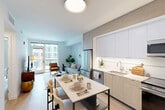 Located at 77 Bruton St in San Francisco, CA, this thoughtfully designed one-bedroom, two-bathroom residence offers a efficient and modern single-floor layout. The open-concept living, dining, and kitchen area forms the heart of the home, where light wood-tone flooring, clean white walls, and abundant natural light create a bright and welcoming atmosphere. A sliding glass door in the living room opens to a balcony, seamlessly connecting indoor and outdoor living.

The kitchen is outfitted with two-tone cabinetry—crisp white uppers paired with warm wood lowers—stainless steel appliances including a range, microwave, and refrigerator, and a clean white countertop with an undermount sink. A marble-topped dining table with seating sits adjacent, making the space ideal for both cooking and entertaining.

The spacious primary bedroom accommodates a full bedroom suite comfortably, featuring light wood flooring, a dedicated closet, and a calm, neutral palette. Two well-appointed bathrooms complete the unit: one features a generous walk-in shower with white subway tile, grey stone lower tile, and mosaic tile flooring, while the other includes a wide vanity with wood cabinetry and built-in shelving. The overall aesthetic is clean, contemporary, and highly functional.