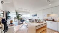 Located at 126 W Main St in the heart of downtown Durham, NC, this modern one-bedroom, one-bathroom residence offers a thoughtfully designed open-concept layout with striking architectural details throughout. The combined kitchen and living area serves as the centerpiece of the home, where floor-to-ceiling windows flood the space with natural light and frame breathtaking panoramic views of the Durham skyline. Hardwood-style flooring flows throughout the living areas, enhancing the bright, airy atmosphere. The kitchen is outfitted with crisp white cabinetry, quartz countertops, a white tile backsplash, stainless steel appliances, and a central island with seating — ideal for both cooking and casual dining. Track lighting overhead adds a contemporary touch. The living room takes full advantage of the expansive glazing, with sliding glass doors opening to a private balcony with sweeping city views. The bedroom features plush carpeting, a ceiling fan, a dedicated closet, and its own access to the balcony through floor-to-ceiling sliding doors. The bathroom is finished with a wood-toned vanity, quartz countertop, and clean white tile flooring. A dedicated entryway closet completes this well-appointed urban residence.