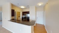 This single-floor residence offers a thoughtfully designed layout with a warm, neutral color palette throughout. The open-concept kitchen is a standout feature, showcasing dark espresso cabinetry, stainless steel appliances including a gas range and built-in microwave, and a sweeping granite-topped breakfast bar that flows into the main living areas. Light hardwood-style flooring grounds the kitchen and entry areas, while plush carpeting extends throughout the living room and bedrooms.

The spacious living room is bright and inviting, with large windows and sliding glass door access allowing abundant natural light to fill the room. A fireplace anchors one wall, adding a focal point and cozy atmosphere, while a ceiling fan overhead provides year-round comfort.

The bedrooms are generously sized, each featuring ceiling fans with light kits, wide windows with blinds, and plush carpeting. One bedroom includes access to a walk-in closet with built-in shelving, providing ample storage.

Two full bathrooms serve the residence. The primary bathroom features a standalone shower with frosted glass sliding doors and a dark-cabinetry vanity with a wide mirror. The secondary bathroom offers a full soaking tub and shower combo, paired with a matching dark-wood vanity. Both bathrooms are finished with warm wall tones and modern brushed nickel fixtures.