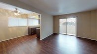 This single-floor unit offers a thoughtfully designed layout that balances open living spaces with functional private areas. The living room is a highlight, featuring rich dark hardwood-style flooring that extends throughout the main areas, neutral-toned walls, and a sliding glass door that opens to a private balcony, allowing for an abundance of natural light and outdoor views.

The galley-style kitchen is well-equipped with dark espresso cabinetry, granite-toned countertops, a double stainless steel sink, and full-size appliances including a stainless steel refrigerator, electric range, and overhead ventilation hood. A pass-through opening connects the kitchen to the living area, enhancing the open feel of the space.

The bedrooms are carpeted in warm neutral tones, providing a comfortable and quiet retreat. One bedroom features access to a generously sized walk-in closet with dual hanging rods, offering ample storage. Additional windows in the bedrooms bring in natural light while maintaining privacy.

The bathroom is cleanly finished with a full tub-shower combination, dark vanity cabinetry with a granite-toned countertop, and hardwood-style flooring that ties into the overall aesthetic of the unit. Throughout the space, consistent finishes and a neutral color palette create a cohesive and inviting atmosphere.