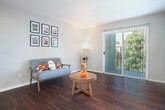 Located at 530 Sunnyview Dr in Pinole, California, this two-bedroom, two-bathroom residence offers a well-organized single-level layout with a cohesive, neutral design throughout. Dark hardwood-style flooring runs consistently across all living areas, adding warmth and visual continuity to the space.

The living room is bright and inviting, featuring a sliding glass door with vertical blinds that opens onto a private balcony, allowing natural light to fill the room. Adjacent to the living area, the dining room provides a seamless transition for everyday living and entertaining.

The galley-style kitchen is efficiently designed with white cabinetry lining both sides, offering ample storage and counter space. White appliances, including a refrigerator, electric range, and built-in microwave, are neatly integrated into the layout.

The primary bedroom is generously sized and includes a large sliding-door closet, providing substantial storage. The second bedroom also features a sliding closet and a window with views of surrounding greenery. Three closets total are distributed throughout the home.

Both bathrooms continue the dark flooring aesthetic. The primary bath includes a sliding-glass enclosed shower, while the second bathroom features a shower-tub combination and a well-lit vanity with a large mirror. Hallways connect the rooms efficiently, completing this practical and comfortable single-level home.