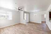 Located at 2225 W Frye Rd in Chandler, Arizona, this single-story 2-bedroom, 2-bathroom home offers a well-organized layout across a comfortable footprint. The open living and dining area is finished with wood-look flooring throughout and features a ceiling fan, a chandelier-style light fixture, and a large window that allows natural light to fill the space. A partial dividing wall separates the living area from the dining space, adding subtle architectural definition.

The kitchen is equipped with rich dark wood cabinetry, light quartz-style countertops, and black appliances, including a full-size refrigerator. The layout provides ample counter and storage space for everyday use.

Both bedrooms continue the wood-look flooring and are fitted with ceiling fans and window blinds. The primary bedroom is generously sized and includes a walk-in closet with built-in shelving and a hanging rod. The second bedroom also offers good proportions and natural light. One bedroom features sliding glass doors leading directly to a private patio, adding convenient outdoor access.

The two bathrooms are clean and functional, with one featuring a tub/shower combination, wood-look flooring, and dark vanity cabinetry. A dedicated in-unit laundry room with a washer and dryer and overhead shelving adds everyday convenience. A hallway connects all rooms, completing this practical and well-appointed home.