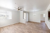 Located at 2225 W Frye Rd in Chandler, Arizona, this single-story 2-bedroom, 2-bathroom home offers a well-organized layout across a comfortable footprint. The open living and dining area is finished with wood-look flooring throughout and features a ceiling fan, a chandelier-style light fixture, and a large window that allows natural light to fill the space. A partial dividing wall separates the living area from the dining space, adding subtle architectural definition.

The kitchen is equipped with rich dark wood cabinetry, light quartz-style countertops, and black appliances, including a full-size refrigerator. The layout provides ample counter and storage space for everyday use.

Both bedrooms continue the wood-look flooring and are fitted with ceiling fans and window blinds. The primary bedroom is generously sized and includes a walk-in closet with built-in shelving and a hanging rod. The second bedroom also offers good proportions and natural light. One bedroom features sliding glass doors leading directly to a private patio, adding convenient outdoor access.

The two bathrooms are clean and functional, with one featuring a tub/shower combination, wood-look flooring, and dark vanity cabinetry. A dedicated in-unit laundry room with a washer and dryer and overhead shelving adds everyday convenience. A hallway connects all rooms, completing this practical and well-appointed home.
