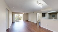 Located at 8891 Okeechobee Blvd in West Palm Beach, FL, this well-appointed 2-bedroom, 2-bathroom single-floor residence offers a thoughtfully designed layout with consistent finishes throughout. Rich wood-look flooring flows through the main living areas, complementing the neutral warm-toned walls and textured ceilings.

The open living room is bright and airy, featuring a ceiling fan and a sliding glass door that floods the space with natural light and provides access to an outdoor area with greenery views. A dedicated dining area connects seamlessly to the kitchen, which is a standout feature of the home. It boasts dark espresso cabinetry, striking marble-style countertops with a matching backsplash, stainless steel appliances including a range, microwave, dishwasher, and refrigerator, along with a skylight that adds additional natural light.

Both bedrooms are comfortably sized, with the spacious primary bedroom offering a ceiling fan and a broad window with outdoor views. The two bathrooms are finished with stone-look tile flooring, dark vanity cabinetry, and granite-style countertops. The full bathroom includes a tub-shower combo with coordinating tile surround. Additional utility space with louvered closet doors and an electrical panel area is tucked conveniently near the kitchen.