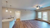 Located on E Revere Boulevard in Huntsville, Alabama, this single-story unit offers a well-designed, open-concept layout that balances functionality with modern finishes throughout.

The kitchen serves as a central highlight, featuring dark espresso cabinetry, granite countertops, a subway tile backsplash, and a full suite of stainless steel appliances including a refrigerator, electric range, and built-in microwave. A peninsula with an undermount double sink and pendant lighting above creates a natural transition into the living area, which is finished with warm hardwood-style flooring and neutral-toned walls. A ceiling fan with a light fixture adds both comfort and style to the main living space, which receives natural light through windows fitted with blinds.

The bedrooms are carpeted and generously sized, each equipped with ceiling fans. The bathroom includes granite-topped dark vanity cabinetry, tile flooring, and accessible grab bars near the shower area. A dedicated laundry area houses a full-size side-by-side washer and dryer with overhead shelving for added storage. The entry area provides closet space, completing this thoughtfully arranged single-level home.