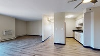 This single-floor unit offers a practical and well-organized layout across two bedrooms and two bathrooms. The open living area features light wood-tone laminate flooring, neutral beige walls, and a ceiling fan, creating a bright and comfortable atmosphere. Baseboard heating runs throughout the main living space, ensuring efficient warmth. A central half-wall divides the living area from the kitchen zone, maintaining an open feel while defining each space clearly.

The galley-style kitchen is efficiently designed with white shaker cabinetry, dark granite countertops, light wood-tone flooring, and stainless steel appliances including a range and dishwasher. Ample upper and lower cabinetry provides generous storage throughout.

Both bedrooms feature plush wall-to-wall carpeting and neutral tones. The primary bedroom includes dual sliding closets, offering substantial storage capacity, along with a window that allows natural light. The second bedroom similarly benefits from a window with blinds and baseboard heating.

The bathrooms echo the kitchen's aesthetic with white cabinetry and dark granite vanity countertops. A hallway connects the bedrooms and bathrooms, contributing to a logical, easy-to-navigate floor plan throughout the unit.