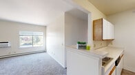 Located at 999 E First Avenue in Broomfield, Colorado, this 2-bedroom, 1-bathroom residence offers a well-organized single-floor layout designed for comfortable everyday living. The kitchen is a functional galley-style space featuring white cabinetry with wood accents, a full suite of white appliances including a refrigerator and range, light-toned flooring, and ample counter space along both walls. A pass-through counter opens the kitchen toward the living area, enhancing the sense of connectivity throughout the unit. The living area is finished with plush carpeting and receives natural light through a large window with outdoor views of the surrounding greenery. Both bedrooms are carpeted and feature windows overlooking the exterior, with baseboard heating for year-round comfort. The primary bedroom includes a ceiling fan and offers generous proportions, while each bedroom benefits from dedicated closet space fitted with wire shelving for organized storage. The bathroom is equipped with a shower/tub combination, a single vanity with under-sink cabinet storage, a lighted mirror, and wood-look flooring. A connecting hallway ties the rooms together efficiently. The overall aesthetic is clean and neutral, providing a bright, move-in-ready environment throughout.