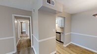 This single-floor unit offers a practical and cohesive layout designed for comfortable everyday living. The interior is finished throughout in warm neutral tones, with light wood-style flooring running through the main living areas and hallways, transitioning to plush carpet in the bedrooms.

The galley-style kitchen is well-appointed, featuring stainless steel appliances — including a refrigerator, range with over-the-range microwave, and dishwasher — paired with white cabinetry, granite-style countertops, and a stainless steel sink. The kitchen opens toward the dining and living areas, maintaining an open and connected feel.

The living area is spacious and bright, benefiting from a sliding glass door that leads to a balcony and allows natural light to fill the room. Horizontal blinds provide privacy and light control.

The bedrooms are carpeted and generously sized, each equipped with a ceiling fan with light fixture and windows that bring in natural light. One bedroom features convenient access to an adjoining bathroom area with closet.

The bathroom includes a full tub-shower combination with tile surround, a granite-topped vanity, and wood-style flooring. Throughout the unit, textured ceilings, white trim, and consistent neutral wall tones contribute to a clean, cohesive aesthetic.