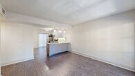 Located at 1659 Piedmont Ave NE in Atlanta, GA, this well-appointed one-bedroom unit offers a thoughtfully designed single-level layout that maximizes every square foot. Rich hardwood-style flooring runs throughout the entire space, creating a cohesive and contemporary aesthetic.

The heart of the unit is an open-concept living, dining, and kitchen area. The modern kitchen features sleek, flat-front cabinetry in a light gray finish, a stone countertop peninsula with pendant lighting, stainless steel appliances including a refrigerator, range, and dishwasher, and under-cabinet lighting. Track lighting overhead adds to the bright, functional atmosphere. A pantry provides additional storage.

The living and dining areas flow naturally from the kitchen, bathed in natural light from a sliding glass door that opens to a private balcony with outdoor views. A stylish pendant light anchors the dining zone.

The bedroom is a comfortable, well-proportioned retreat featuring a ceiling fan, a second sliding glass door with balcony access, and a dedicated closet. The hallway connects the main living areas to the bedroom and includes in-unit laundry, adding everyday convenience. Clean white walls and modern dark-toned interior doors complete the polished, move-in-ready feel of this Atlanta residence.