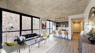 Located in Chicago's vibrant West Loop neighborhood, this single-floor unit at 158 N Ada St showcases a compelling blend of industrial and contemporary design. The open-concept living and kitchen area is anchored by a striking exposed concrete ceiling that runs throughout, complemented by light hardwood-style flooring and floor-to-ceiling black-framed windows that flood the space with natural light and offer views of the surrounding urban streetscape.

The kitchen is thoughtfully designed with dark wood cabinetry, a decorative tile backsplash, stainless steel appliances, and a generous white waterfall-edge island with bar seating for three—illuminated by a trio of Edison-style pendant lights and a track lighting fixture above. The living area benefits from corner window placement, enhancing both light and openness.

The bedrooms continue the industrial aesthetic with exposed concrete ceilings and large black-framed windows providing natural light. One bedroom features direct access to an outdoor balcony. The bathrooms are finished in a clean, modern style with large-format white tile flooring, dark vanity cabinetry, LED-backlit mirrors, and matte black fixtures, with one bathroom offering a soaking tub and walk-in shower combination.