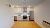 Located at 2901 S Wayzata Blvd in Minneapolis, Minnesota, this single-floor unit offers a clean, contemporary design with consistent light hardwood flooring throughout, creating a cohesive and inviting atmosphere.

The kitchen is a standout feature, showcasing crisp white shaker-style cabinetry, white quartz countertops, and a herringbone tile backsplash. Stainless steel appliances — including a range with a stainless hood vent, dishwasher, and full-size refrigerator — complete the modern, functional space. Recessed lighting adds a bright, polished feel.

The living area is open and airy, equipped with a ceiling fan and a wall-mounted climate control unit. A window allows natural light to filter in, keeping the space feeling fresh and comfortable.

The bathroom features a soaking tub, a stylish vanity with white countertops, and matte black hardware accents that lend a modern touch. A shaker-panel door leads directly into a generously sized walk-in closet outfitted with wire shelving and ample storage on multiple walls.

Throughout the unit, clean white walls, matte black fixtures, and light wood flooring create a modern, neutral palette that is both versatile and inviting — ideal for comfortable everyday living.