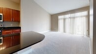 This 620 square foot apartment in Omaha, NE offers a contemporary living space on a single floor. The layout is efficiently designed to maximize the available area. The modern kitchen is a standout feature, boasting rich wood cabinetry, sleek black countertops, and stainless steel appliances including a built-in microwave and full-sized refrigerator. The kitchen's hardwood flooring adds warmth and contrasts nicely with the carpeted living areas.

The open plan design creates a sense of spaciousness, with the living room seamlessly connecting to other areas of the home. Large windows in the living room allow for ample natural light, enhancing the overall ambiance. The space is versatile, suitable for both relaxation and entertaining.

The apartment showcases a mix of flooring types, with plush carpeting in the living areas and bedroom, providing comfort underfoot. The neutral wall colors throughout offer a blank canvas for personalization. A closet provides valuable storage space, while ceiling fans contribute to air circulation and comfort. The thoughtful design makes efficient use of the compact 620 square feet, creating a cozy yet functional living environment.