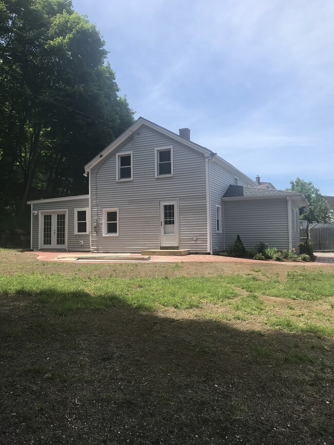 Large back yard that has just been reseeded. We maintain the lawn. The French Doors on the left open to a large 'Three Season Room' that is unfinished. - 51 Pleasant St