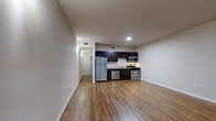 Located in Oakland, CA (94608), this single-floor unit offers a cohesive and functional layout finished with warm-toned wood-style flooring throughout. The open living area flows directly into the kitchen, creating a seamless and practical living space. The kitchen is well-equipped with dark espresso cabinetry, stone-look countertops, and a full suite of stainless steel appliances including a refrigerator, dishwasher, gas range, and built-in microwave — providing everything needed for everyday cooking. Recessed lighting illuminates the space efficiently. The bedroom features natural light from a wide multi-panel window with blinds and includes a spacious sliding-door closet with a full-width hanging rod. The bathroom is neatly appointed with a dark wood vanity, light stone countertop, a large mirror, and wood-style flooring that ties the space together cohesively. Neutral wall tones and clean white baseboards contribute to a bright, move-in-ready atmosphere. The unit's straightforward single-level design ensures ease of navigation, while its location in Oakland's 94608 zip code offers convenient access to the broader East Bay area.