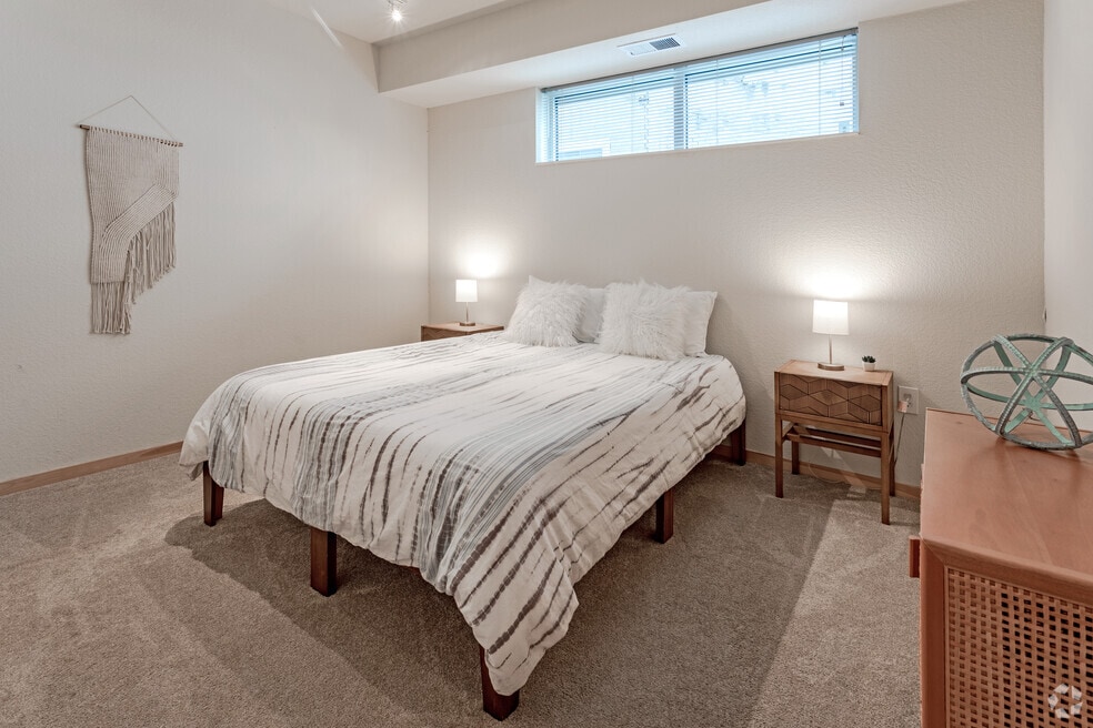 Cozy bedroom with a queen-size bed, white bedding with black stripes, and two plush white pillows.