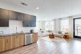 Located at 397 N Central Ave in Hapeville, GA, this well-designed 2-bedroom, 2-bathroom residence offers a thoughtful single-floor layout with modern finishes throughout. The open-concept living and kitchen area serves as the heart of the home, featuring wood-look luxury vinyl plank flooring, sleek dark cabinetry with wood-toned lower cabinets, dark countertops, and stainless steel appliances. Large windows flood the space with natural light and offer pleasant outdoor views, while a ceiling fan adds comfort to the airy living room. A welcoming hallway connects the living areas to the private quarters, accented by recessed lighting and crisp white walls. The primary bedroom is a comfortable retreat with plush carpet, generous windows, a ceiling fan, and its own en-suite bathroom featuring wood-toned cabinetry and dark countertops. A walk-in closet with wire shelving provides ample storage. The second bedroom also features carpet flooring, a ceiling fan, and a bright window. The second full bathroom mirrors the modern aesthetic with hardwood-style flooring, a vanity with matching cabinetry, and a shower. Throughout the residence, clean lines, neutral tones, and quality materials create a cohesive, contemporary ambiance ideal for modern living.