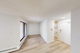 Located in the Oakfield Drive SW community of Calgary, Alberta, this one-bedroom, one-bathroom unit offers a clean and efficiently designed single-floor layout. Light-toned hardwood flooring runs throughout the space, lending a cohesive and modern feel to every room.

The open living and dining area is the heart of the unit, featuring large sliding glass doors that lead to a private balcony and allow natural light to fill the room. A secondary window further brightens the living space, while baseboard heating ensures year-round comfort. The balcony overlooks a treed outdoor setting, providing a pleasant outdoor retreat.

The kitchen is thoughtfully appointed with white cabinetry featuring black hardware accents, a tile backsplash, and ample counter and storage space. It connects conveniently to the main living areas.

The bedroom is a well-proportioned private retreat with its own window for natural light, baseboard heating, and a built-in sliding-door closet for storage. Additional closet space is available throughout the unit via multiple dedicated storage areas.

The bathroom is finished in a clean, all-white palette, complete with a full soaker tub and shower combination with tiled surround, a vanity with integrated sink, and updated fixtures. The hallways connect all areas smoothly, completing a functional and cohesive floor plan.
