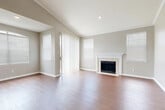 This thoughtfully designed 2-bedroom, 2-bathroom single-floor home offers a comfortable and functional layout across a generous floor plan. The living room serves as the centerpiece of the home, showcasing vaulted ceilings with crown molding, warm hardwood-style flooring, and a classic tiled fireplace with a white mantel. Large sliding glass doors and multiple windows flood the space with natural light while providing outdoor views. The kitchen is well-equipped with white cabinetry, granite countertops, a chevron-pattern tile backsplash, and stainless steel appliances, including a range and over-the-range microwave. A sliding glass door in the kitchen area adds additional access and light. The spacious primary bedroom features plush carpeting, crown molding, and a ceiling fan, offering a comfortable retreat. The bathrooms are finished with granite-topped vanities and white subway tile surrounds over soaking tubs. Two closets provide ample storage throughout. A dedicated laundry room includes wire shelving and washer/dryer hookups. Neutral gray tones throughout the home create a cohesive and modern aesthetic, making this a move-in-ready space with lasting appeal.