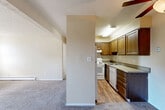 Located at 781 Hathaway Dr in Colorado Springs, CO, this one-bedroom, one-bathroom unit offers a practical and comfortable single-floor layout. The living area is bright and open, featuring plush carpeting, baseboard heating, a ceiling fan, and sliding glass doors that lead to a private balcony with outdoor views. A secondary window brings in additional natural light, enhancing the spacious feel of the room. The living space flows into a dedicated dining area and connects seamlessly to the kitchen, which is partially separated by a structural column. The kitchen features rich dark wood cabinetry, a double sink, a white electric range, a dishwasher, and light wood-style flooring, providing a functional contrast to the carpeted living spaces. The bedroom is well-proportioned, carpeted, and includes multiple closets for generous storage. A ceiling fan adds comfort, and a window allows for natural light. The full bathroom is clean and straightforward, featuring a white tub-shower combination, wood-style flooring, and neutral-toned walls. A hallway with additional closets connects the main areas of the unit. The textured ceilings are consistent throughout, lending a cohesive character to the entire space.