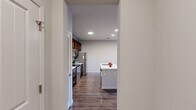 Located at 86 Setter Cir in Fredericksburg, VA, this well-appointed one-bedroom, two-bathroom residence offers a thoughtfully designed single-floor layout. The open-concept kitchen and living area serves as the heart of the home, showcasing rich dark-wood cabinetry, stainless steel appliances including a refrigerator, range, and microwave, and a stylish tile backsplash. A central kitchen island with a white quartz countertop and built-in sink provides casual seating and additional prep space. Hardwood-style flooring flows throughout the main living areas, adding warmth and continuity. The living room is bright and airy, featuring a ceiling fan, large windows with blinds, and direct access to a private balcony with outdoor views. The bedroom is carpeted for comfort and receives natural light through a window with blinds. The bathrooms are cleanly finished, with one featuring a full tub-shower combination with tile surround and brushed nickel fixtures. Additional highlights include a dedicated entrance, a closet for storage, and a neutral color palette throughout that lends a clean, modern aesthetic. The efficient use of space makes this residence a practical and comfortable option in the Fredericksburg area.