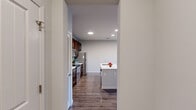 Located at 86 Setter Cir in Fredericksburg, VA, this well-appointed one-bedroom, two-bathroom residence offers a thoughtfully designed single-floor layout. The open-concept kitchen and living area serves as the heart of the home, showcasing rich dark-wood cabinetry, stainless steel appliances including a refrigerator, range, and microwave, and a stylish tile backsplash. A central kitchen island with a white quartz countertop and built-in sink provides casual seating and additional prep space. Hardwood-style flooring flows throughout the main living areas, adding warmth and continuity. The living room is bright and airy, featuring a ceiling fan, large windows with blinds, and direct access to a private balcony with outdoor views. The bedroom is carpeted for comfort and receives natural light through a window with blinds. The bathrooms are cleanly finished, with one featuring a full tub-shower combination with tile surround and brushed nickel fixtures. Additional highlights include a dedicated entrance, a closet for storage, and a neutral color palette throughout that lends a clean, modern aesthetic. The efficient use of space makes this residence a practical and comfortable option in the Fredericksburg area.