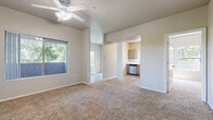 This single-floor residence offers a thoughtfully designed layout that balances comfort and functionality. The open living area is anchored by plush wall-to-wall carpeting and features vaulted ceilings with a ceiling fan, while large windows frame lush green views, filling the space with natural light. The layout flows seamlessly into a dedicated dining area and connects directly to the kitchen.

The kitchen is well-equipped with stainless steel appliances, including an electric range, over-the-range microwave, and dishwasher. Grey cabinetry with brushed nickel hardware pairs with white countertops and a classic subway tile backsplash, complemented by wood-look flooring that adds warmth underfoot.

The bedrooms are generously sized, each featuring soft carpeting, ceiling fans, and ample natural light. One bedroom includes sliding glass doors that open to a private balcony with outdoor views, providing a serene retreat.

The bathrooms are finished with wood-look vinyl flooring. The primary bathroom boasts an extended vanity with grey cabinetry, white countertop, and a wide mirror, while a second bathroom offers a full tub-shower combination with clean white tile surround. Throughout the space, a neutral color palette and consistent finishes create a cohesive, move-in ready environment.